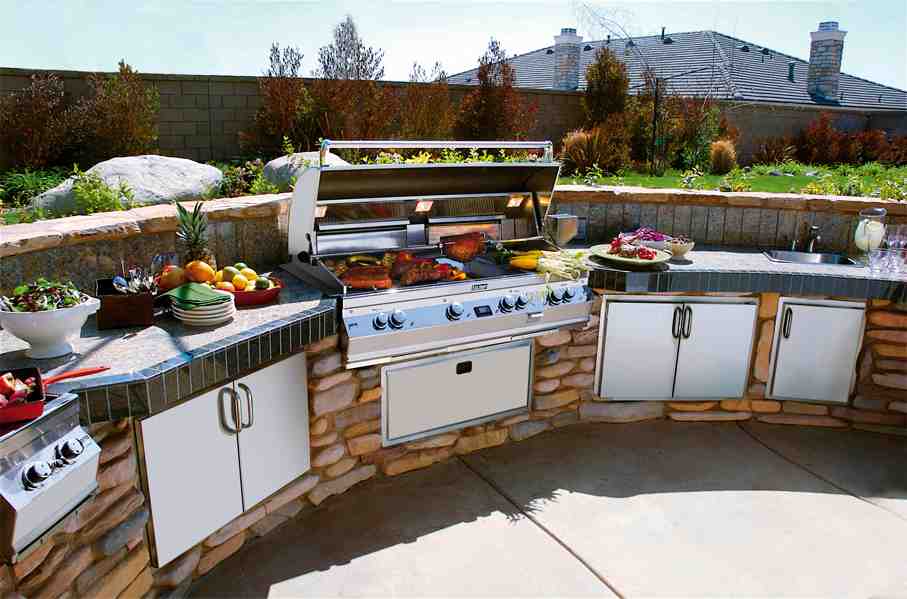 outdoor kitchen island on a sunny day. food cooking on grill and plates and food are on the countertops